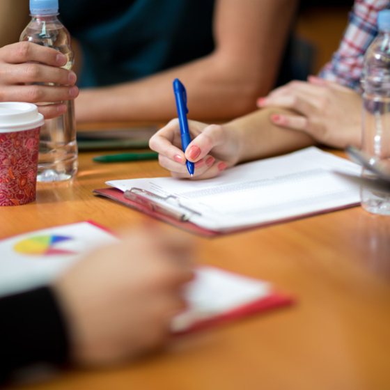 Collega's vullen documenten in aan tafel